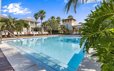 a swimming pool in a villa with palm trees at The Round Up by Oversee 30A in Inlet Beach
