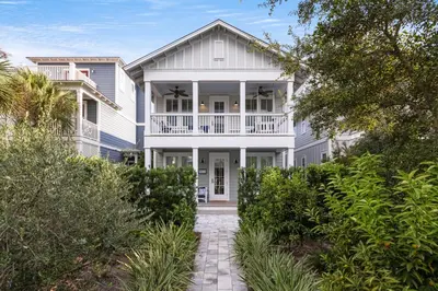 a white house with a porch and a balcony at The Round Up by Oversee 30A in Inlet Beach
