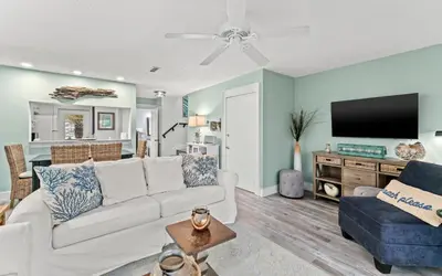 a living room with a white couch and a tv at Tucked-Away at Inlet Beach by Oversee 30A in Inlet Beach
