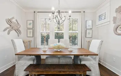 a dining room with a wooden table and chairs at Two Rocking Chairs on a Porch by Oversee 30A in Watersound Beach