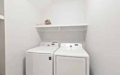 two white washers in a white room with a shelf at Two Rocking Chairs on a Porch by Oversee 30A in Watersound Beach
