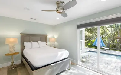 a bedroom with a bed and a large window at Villa Bon Secour by Oversee 30A in Seacrest