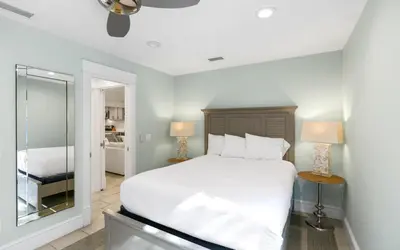 a bedroom with a large white bed and a mirror at Villa Bon Secour by Oversee 30A in Seacrest