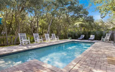 a swimming pool with chairs and a swimming poolvisorvisor at Villa Bon Secour by Oversee 30A in Seacrest