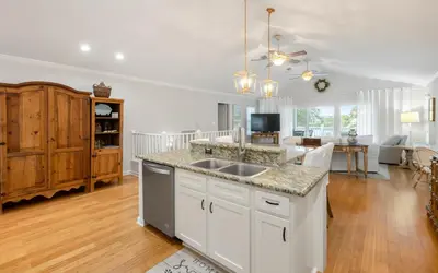 a kitchen with a sink and a living room at Villa Del Lago by Oversee 30A in Seacrest