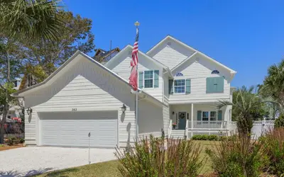 a white house with a flag in front of it at Villa Del Lago by Oversee 30A in Seacrest
