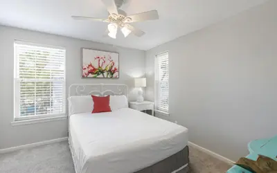a bedroom with a white bed and a ceiling fan at Villa Del Lago by Oversee 30A in Seacrest