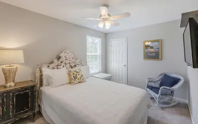 a bedroom with a bed and a ceiling fan at Villa Del Lago by Oversee 30A in Seacrest