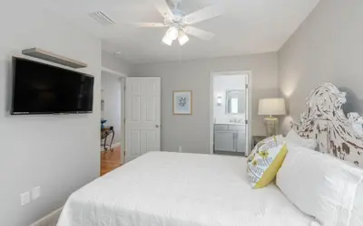 a bedroom with a white bed and a ceiling fan at Villa Del Lago by Oversee 30A in Seacrest