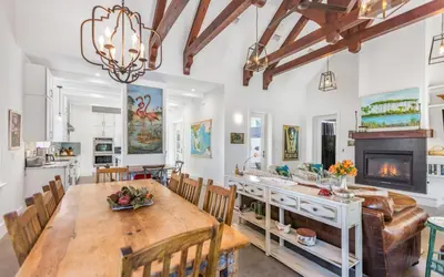 a dining room with a table and a fireplace at Winters End by Oversee 30A in Santa Rosa Beach