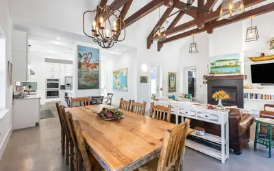 a dining room and kitchen with a large wooden table at Winters End by Oversee 30A in Santa Rosa Beach