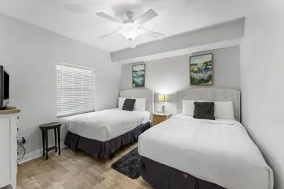 a bedroom with two beds and a ceiling fan at Treasure Island #2302 in Panama City Beach