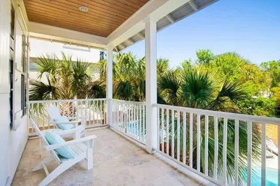 a porch with two chairs and a view of the ocean at Steps to Beach, Large Private Pool, Bikes, Luxury in Santa Rosa Beach