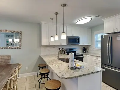 a kitchen with white cabinets and a granite counter top at Villa Chateau #10 in Panama City Beach