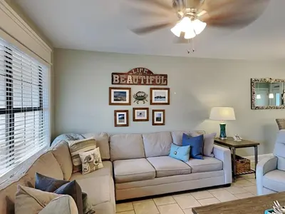 a living room with a couch and a ceiling fan at Villa Chateau #10 in Panama City Beach