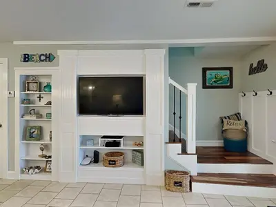 a living room with a staircase with a flat screen tv at Villa Chateau #10 in Panama City Beach