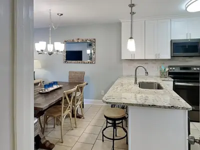 a kitchen with a sink and a table with chairs at Villa Chateau #10 in Panama City Beach