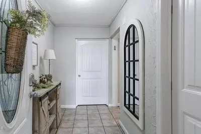 a hallway with a white door and a mirror at 3 Bdrm Condo- 4 pools, hot tub & walk to Beach in Panama City Beach