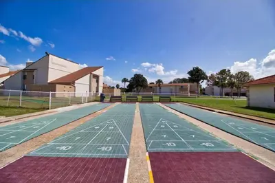 an empty tennis court in front of a building at 3 Bdrm Condo- 4 pools, hot tub & walk to Beach in Panama City Beach