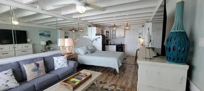 a living room with a couch and a bed at ON THE BEACH! COUPLES GETAWAY,HONEYMOON SWEET, Perfectly Cozy Beach Front Condo, full kitchen, pool, free parking,CHECK-IN AT DOOR in Panama City Beach