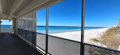 a view of the beach from the balcony of a beach house at ON THE BEACH! COUPLES GETAWAY,HONEYMOON SWEET, Perfectly Cozy Beach Front Condo, full kitchen, pool, free parking,CHECK-IN AT DOOR in Panama City Beach