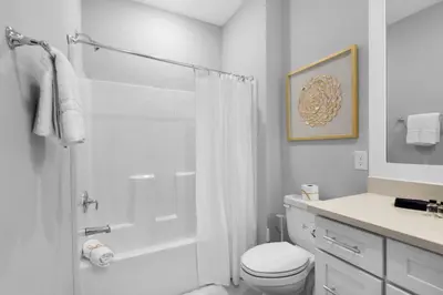 a white bathroom with a shower and a toilet at Wendell's Place in Inlet Beach