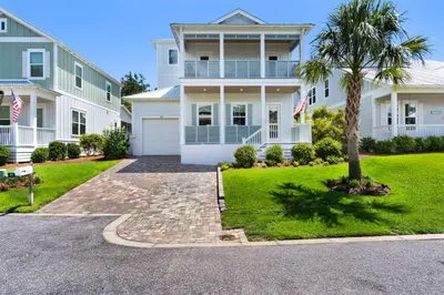a large white house with a palm tree in the driveway at Ocean Pearl in Inlet Beach
