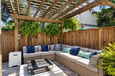 a patio with a couch under a wooden pergola at Ocean Pearl in Inlet Beach