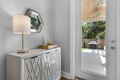 a table with a lamp and a mirror next to a door at Ocean Pearl in Inlet Beach