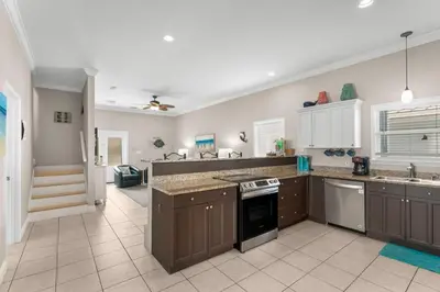 a large kitchen with brown cabinets and appliances at 30A Beach House - Seagrove Escape by Panhandle Getaways in Seagrove Beach