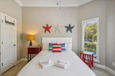 a bedroom with a white bed with stars on the wall at 30A Beach House - Seagrove Escape by Panhandle Getaways in Seagrove Beach