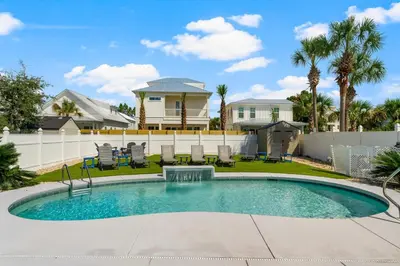 a swimming pool with chairs and a house at 30A Beach House - Seagrove Escape by Panhandle Getaways in Seagrove Beach