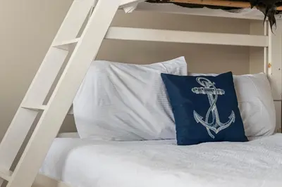 a white bunk bed with a pillow with an anchor on it at 30A Beach House - Seagrove Escape by Panhandle Getaways in Seagrove Beach