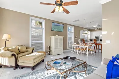 a living room with a ceiling fan and a table at EPIC Beach House with Private Pool, 175 ft to the BEACH, U Gotta See It! in Panama City Beach