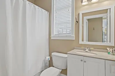a bathroom with a toilet and a sink and a mirror at EPIC Beach House with Private Pool, 175 ft to the BEACH, U Gotta See It! in Panama City Beach