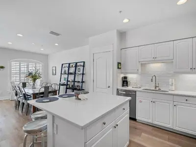 a kitchen with white cabinets and a table with chairs at Villas at Seacrest #B401 - Bella Costa in Inlet Beach
