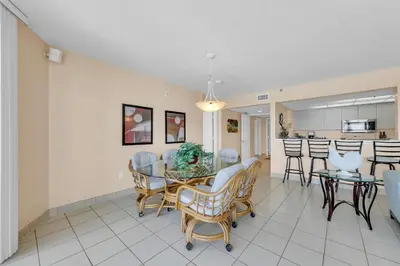 a dining room and living room with a table and chairs at Long Beach Resort 2-1206 in Panama City Beach