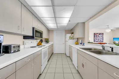 a large kitchen with white cabinets and white appliances at Long Beach Resort 2-1206 in Panama City Beach