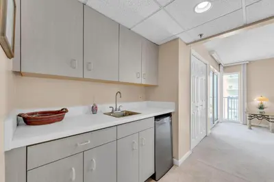 a kitchen with white cabinets and a sink at Long Beach Resort 2-1206 in Panama City Beach