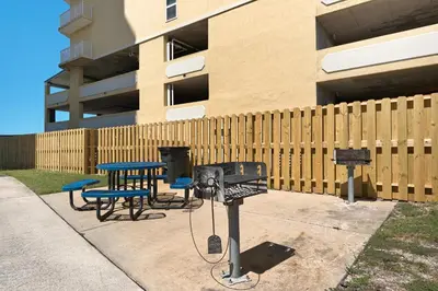 a barbecue grill and picnic table in front of a building at Long Beach Resort 2-1206 in Panama City Beach