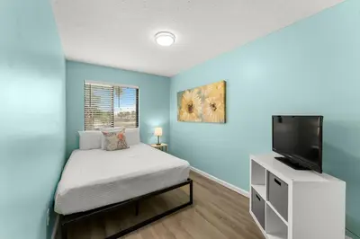 a bedroom with a bed and a flat screen tv at Sand Castle West #G6 in Panama City Beach