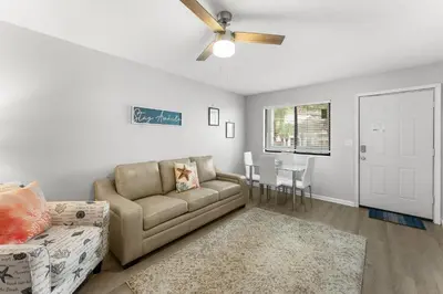 a living room with a couch and a ceiling fan at Sand Castle West #G6 in Panama City Beach