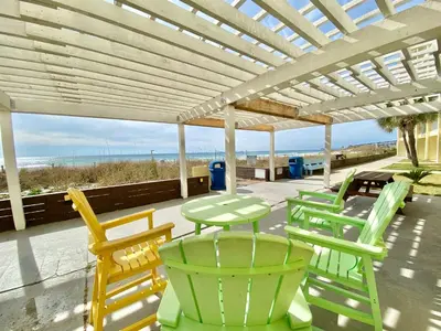 a group of chairs and tables on a patio with the beach at Continental #221 in Panama City Beach