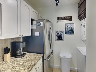 a kitchen with white cabinets and a refrigerator at Edgewater Villa #2008 Gulf Breeze Getaway in Panama City Beach