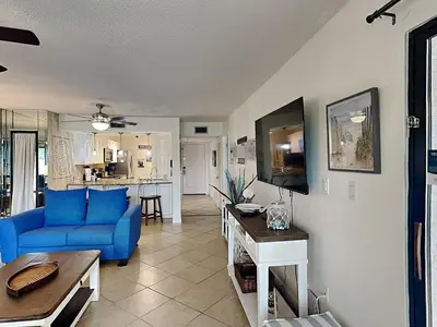 a living room with a blue couch and a kitchen at Edgewater Villa #2008 Gulf Breeze Getaway in Panama City Beach
