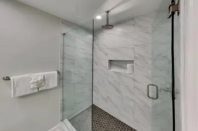a shower with a glass door in a bathroom at Laguna Matata in Panama City Beach