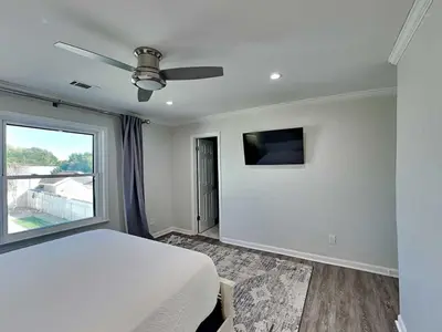 a bedroom with a white bed and a window at Laguna Matata in Panama City Beach