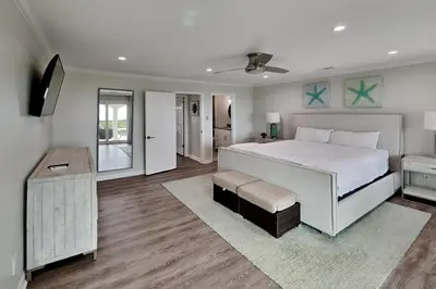 a bedroom with a large white bed and a room at Laguna Matata in Panama City Beach