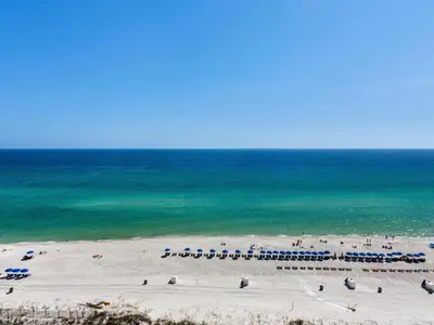 a beach with a bunch of umbrellas and the ocean at Summit Beach Resort 1231 in Panama City Beach