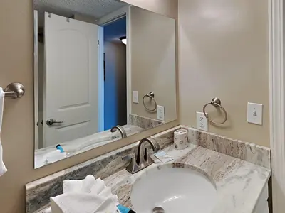 a bathroom with a sink and a large mirror at Mariner East #306 in Panama City Beach